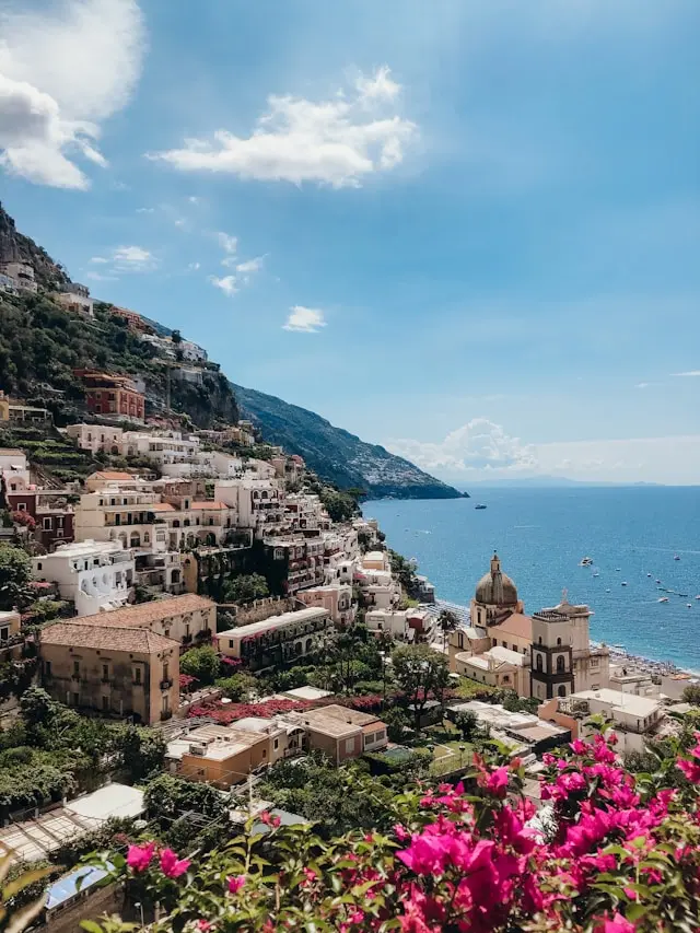 Colorful hillside buildings overlooking the blue Mediterranean Sea in Positano, Italy.