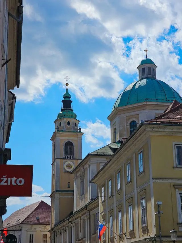 Ljubljana Cathedral in Slovenia, featuring a green copper dome, historic bell tower, and Baroque architecture.