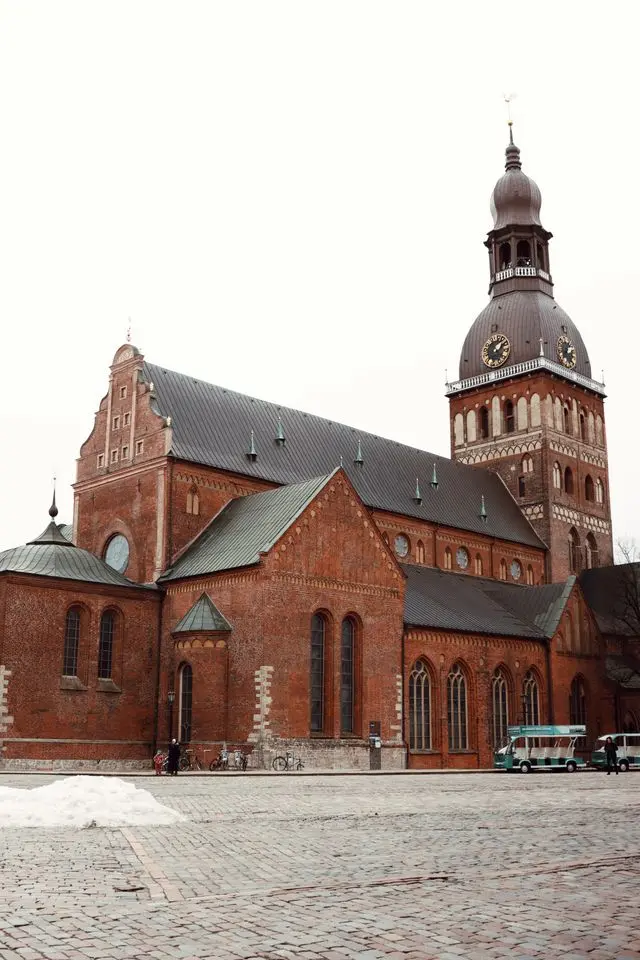 Riga Cathedral in Latvia, featuring historic red-brick architecture, Gothic details, and a domed clock tower.