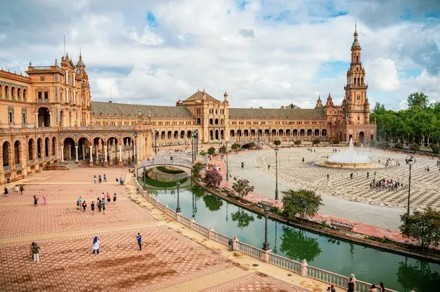 Plaza de España in Seville, Spain, featuring grand architecture, a canal and a spacious tiled plaza.