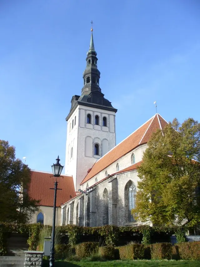 Historic St. Nicholas’ Church in Tallinn, Estonia, featuring a Gothic tower and red-tiled roof.