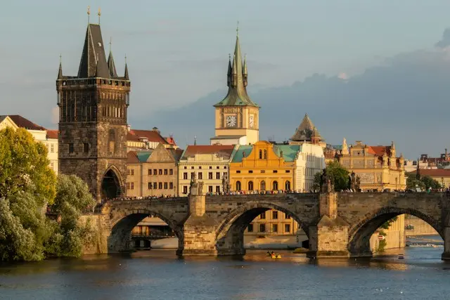 Charles Bridge crossing the Vltava River with Prague’s historic skyline and Old Town Bridge Tower.