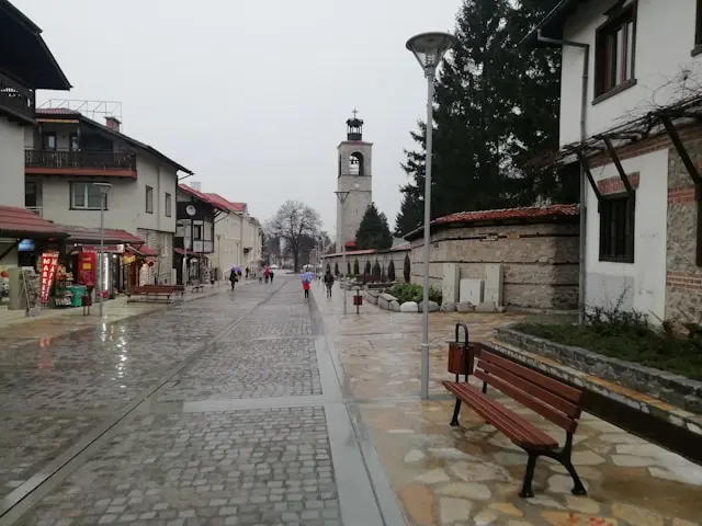 Historic street and church bell tower in Bansko, Bulgaria, on a rainy day