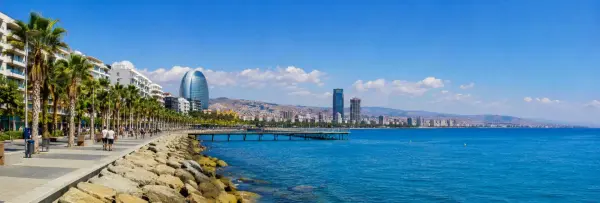 Limassol, Cyprus waterfront promenade with palm trees, turquoise Mediterranean Sea and modern skyline