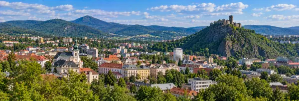 Panoramic view of Ústí nad Labem with historic buildings, green hills and Střekov Castle