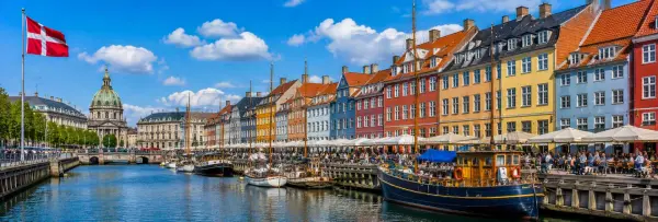 Copenhagen panoramic waterfront with colorful Nyhavn houses and canal boats