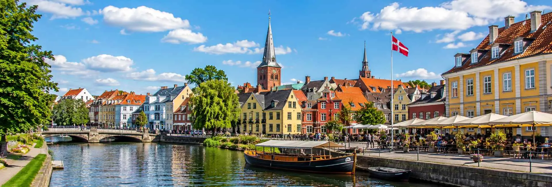 Odense, Denmark, with colorful historic houses, Odense Cathedral, canal, and waterfront cafés