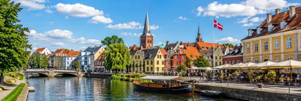 Odense, Denmark, with colorful historic houses, Odense Cathedral, canal, and waterfront cafés