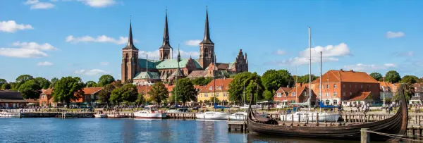 Roskilde, Denmark waterfront with Roskilde Cathedral, boats, and a Viking ship