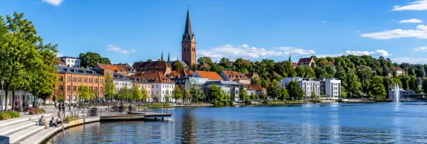 Silkeborg, Denmark waterfront with historic buildings, church and scenic lake under a blue sky