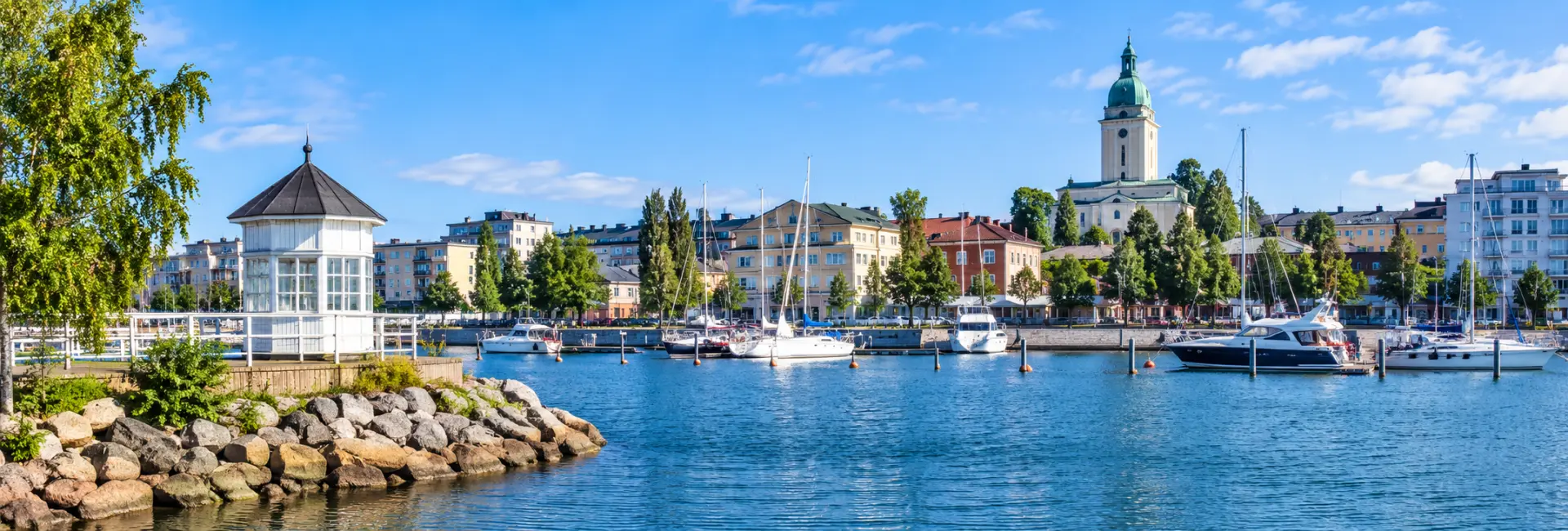 Kotka, Finland harbor with sailboats, waterfront buildings, and a historic green-domed tower