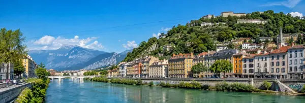 Grenoble, France, with the Isère River, Bastille hillside, historic buildings and Alps in the background.