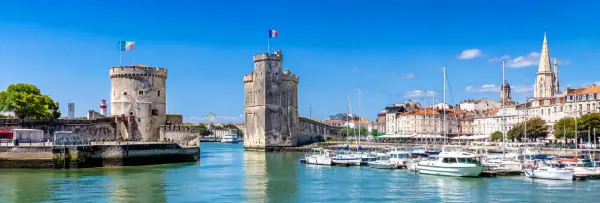 La Rochelle Old Harbour in France with historic medieval towers and boats on a bright sunny day