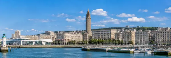 Le Havre, France waterfront with Saint-Joseph Church tower, marina, modern buildings and blue sky.