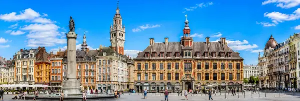 Lille, France historic Grand Place with ornate Flemish buildings and Lille belfry under a blue sky