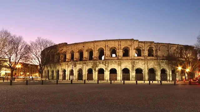 Nîmes Arena illuminated at dusk in Nîmes, France