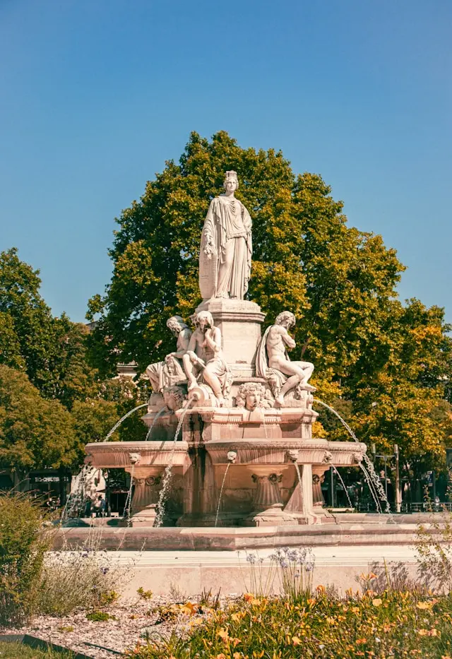 Fontaine Pradier fountain surrounded by trees in Nîmes, France