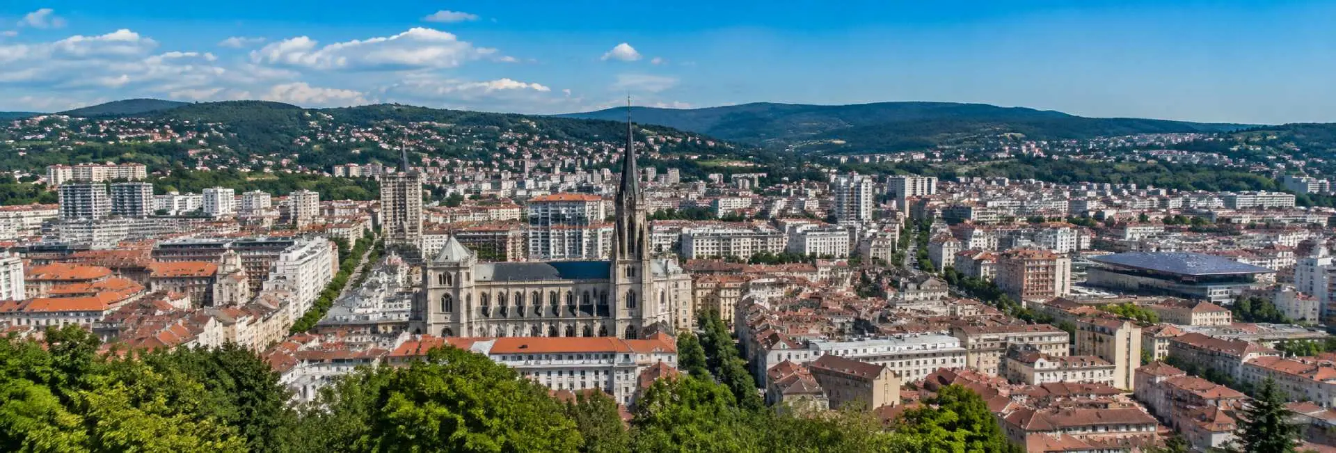 Saint-Étienne, France cityscape with historic architecture, cathedral and surrounding green hills
