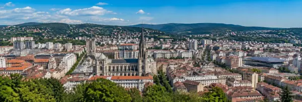 Saint-Étienne, France cityscape with historic architecture, cathedral and surrounding green hills