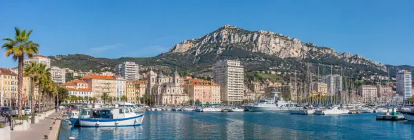 Toulon, France waterfront harbor with sailboats, historic buildings and Mont Faron mountain backdrop