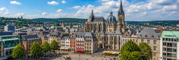 Aachen, Germany skyline with Aachen Cathedral, historic old town and surrounding green hills