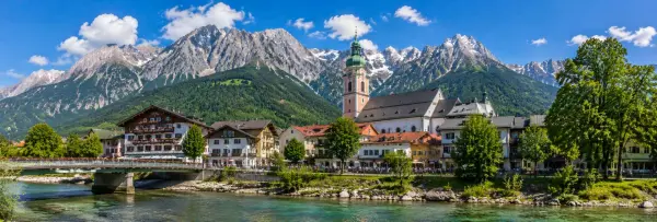 Garmisch-Partenkirchen, Germany with Bavarian chalets, church and snow-capped Alpine mountains