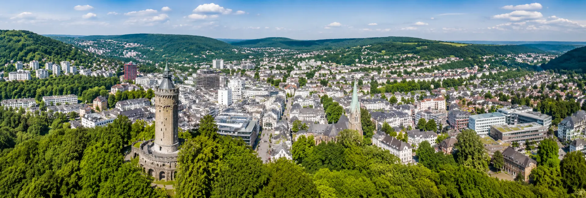 Aerial panoramic view of Hagen, Germany, surrounded by green hills and historic city architecture