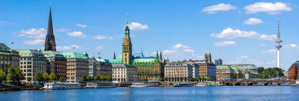 Hamburg Germany waterfront with historic Rathaus, boats, church spires and city skyline