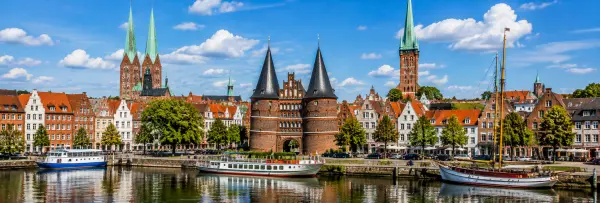 Lübeck, Germany skyline with Holstentor, historic buildings, church spires and riverfront