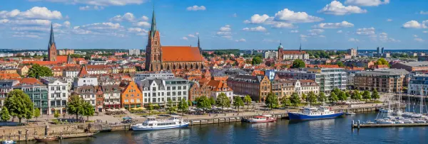 Rostock, Germany skyline with historic churches, red-roofed buildings and harbor waterfront