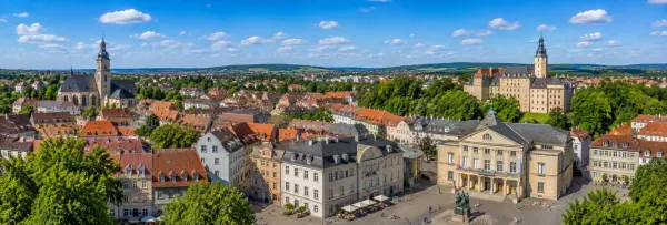 Panoramic view of Weimar, Germany, with historic rooftops, churches, parks and surrounding green countryside