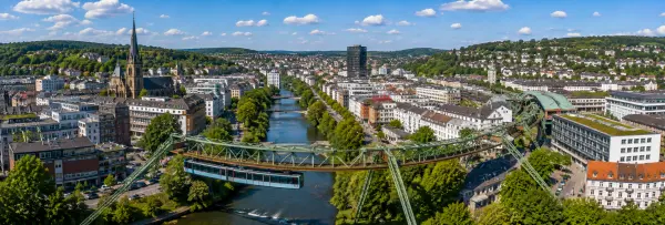 Wuppertal, Germany skyline with the historic suspension railway, river, and green hills