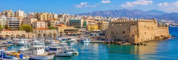 Heraklion, Greece, with Koules Fortress, Venetian harbor, boats and Cretan mountains