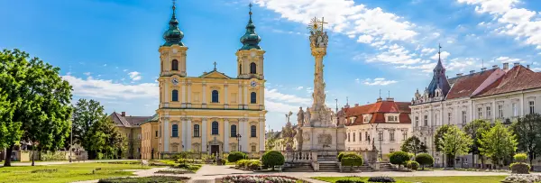 Szombathely, Hungary, featuring the Baroque Cathedral and ornate Holy Trinity Column in a historic city square.