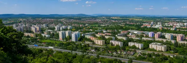 Panoramic aerial view of Tatabánya, Hungary, with apartment blocks, highways, greenery and surrounding hills
