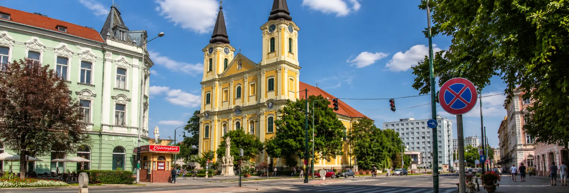Zalaegerszeg church and historic buildings along a sunny city street in Hungary.