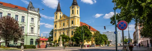 Zalaegerszeg church and historic buildings along a sunny city street in Hungary.