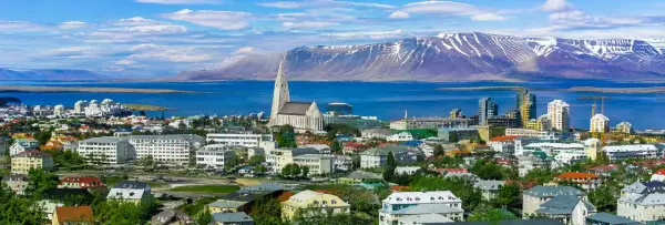 Reykjavik, Iceland skyline with Hallgrímskirkja, colorful buildings, bay and snow-capped mountains