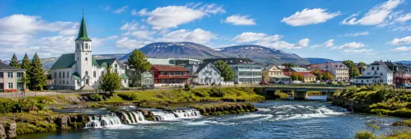 Selfoss, Iceland riverside town with a church, waterfall, bridge, and mountains