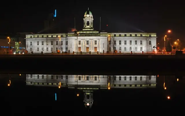Cork City Hall illuminated at night with its reflection in the River Lee, Cork, Ireland