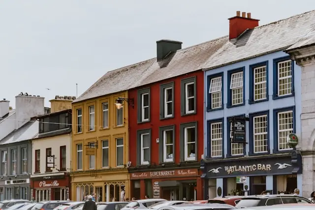 Colorful traditional buildings and shops lining a street in Dingle, Ireland