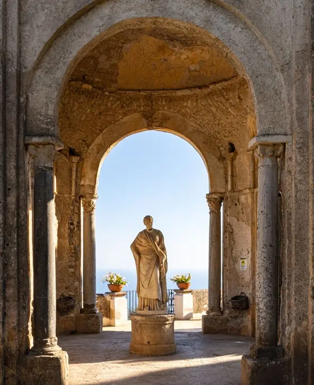 Roman statue framed by an ancient arch at Villa Rufolo in Ravello