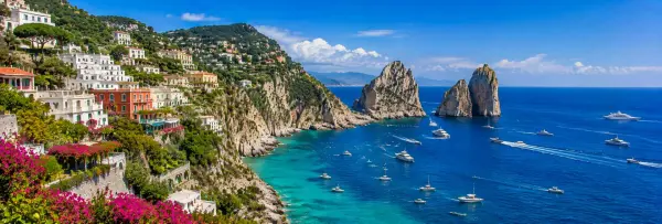 Capri, Italy with colorful hillside villas, turquoise sea and iconic Faraglioni rock formations