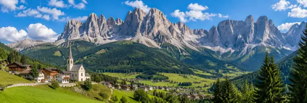 Dolomites, Italy with dramatic limestone peaks, green alpine meadows and a mountain village