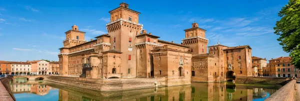 Castello Estense fortress and moat in Ferrara, Italy, under a bright blue sky