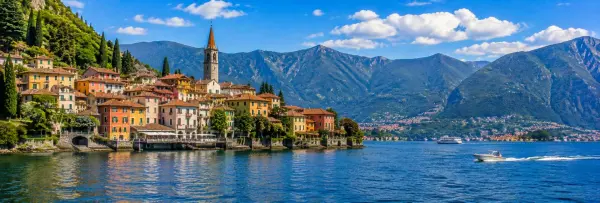 Lake Como, Italy with colorful lakeside village, boats and dramatic Alpine mountains