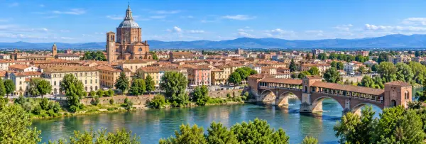 Panoramic view of Pavia, Italy, with its historic skyline, cathedral dome, Ponte Coperto and Ticino River.