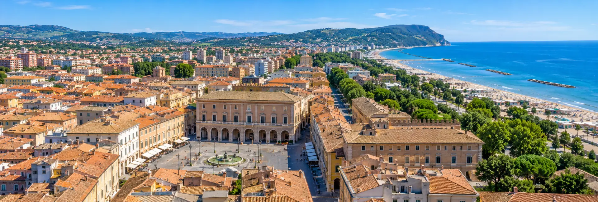 Panoramic view of Pesaro, Italy, with Piazza del Popolo, historic rooftops, Adriatic beach and coastal hills.