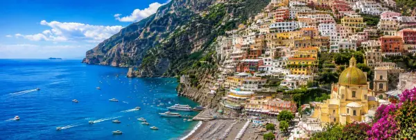 Positano, Italy with colorful cliffside houses, turquoise sea, beach and Amalfi Coast mountains