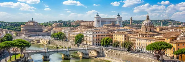 Panoramic view of Rome featuring Castel Sant'Angelo, the Tiber River, and the historic city skyline.